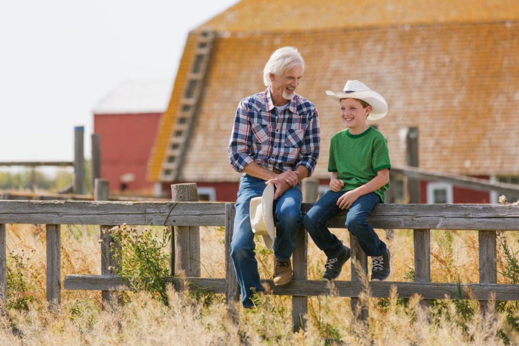 An elderly grandfather bestows knowledge to a young grandson.